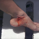 Molly Cavalli’s foot with a very fake looking shark wound (Image: YouTube / CamSoda)